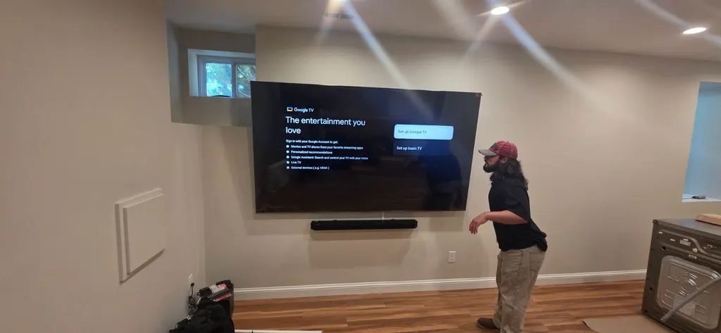 Dom's TV Mounting installer hanging a large TV on a living room wall