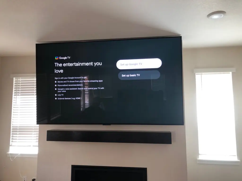 Google TV and wall mounted soundbar above a fireplace for a home theater setup