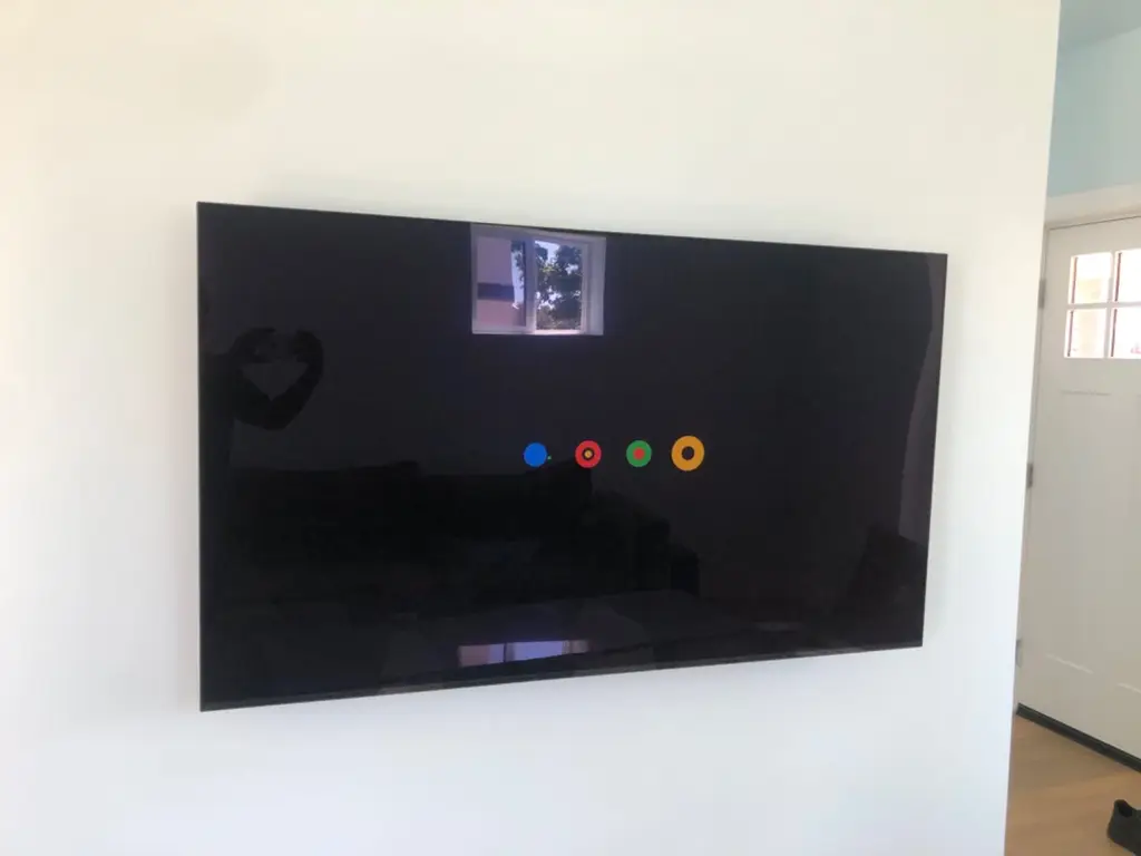 Large flat-screen TV mounted close to a plain white wall with no cords showing