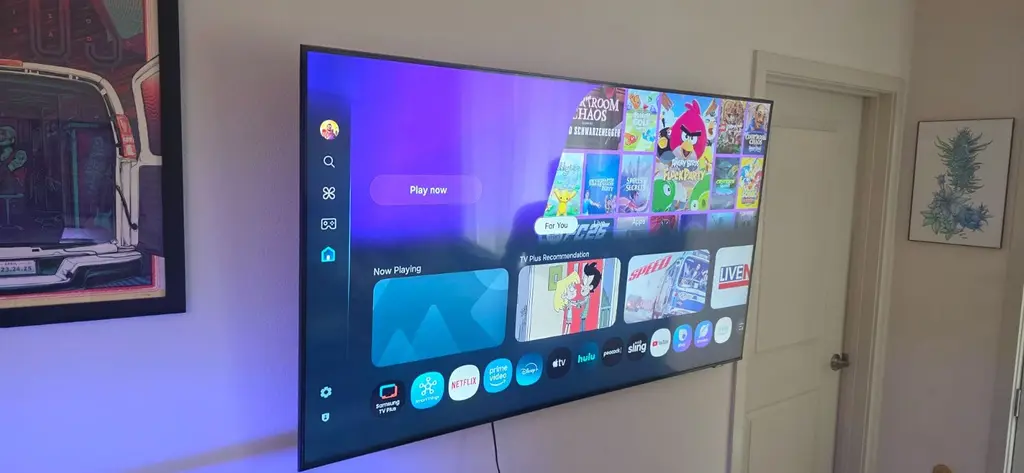Large smart TV wall mounted for a home entertainment setup with ambient lighting