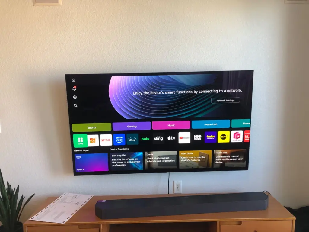 LG TV wall mounted above a console with a soundbar in a Lakewood, CO home