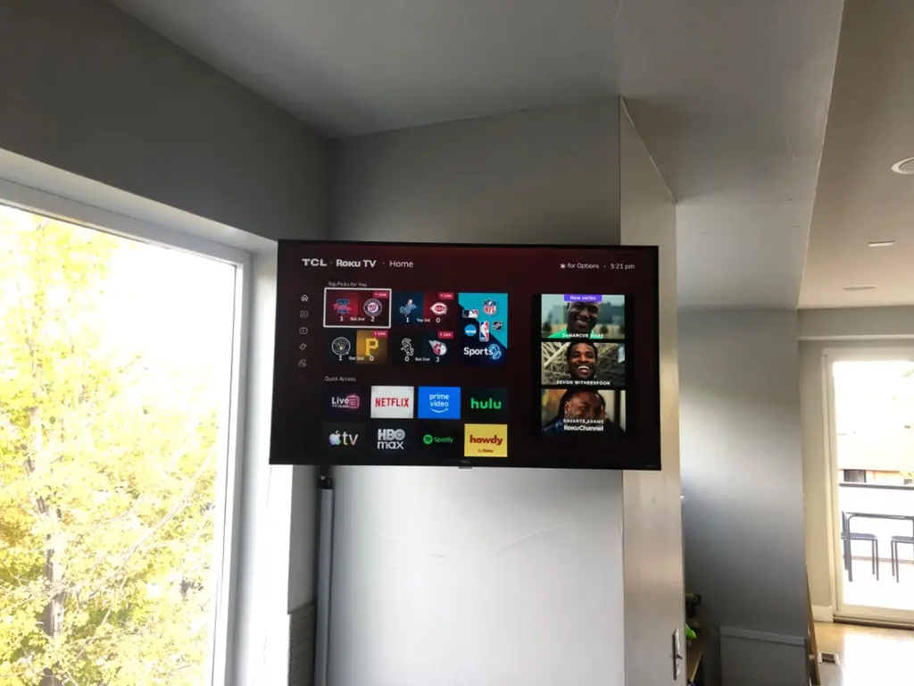 TCL Roku TV mounted in a bright corner by a window in Loveland, CO