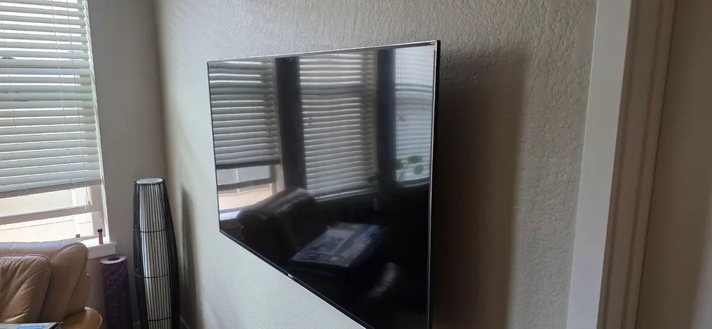 TV mounted on a wall next to a window