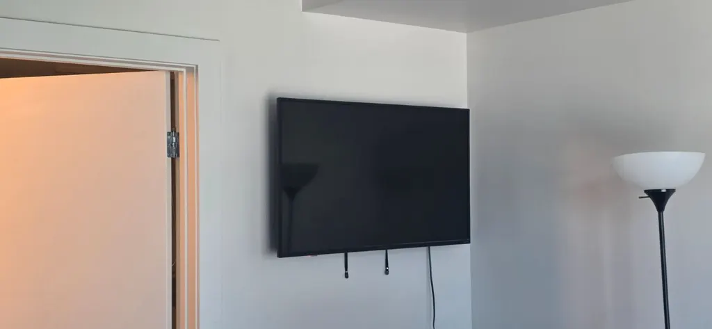 TV mounted flat on a white living room wall