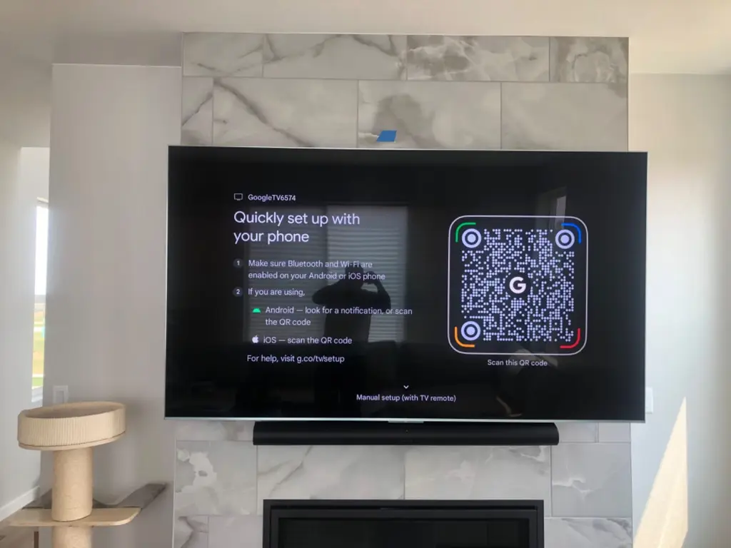 TV and soundbar mounted on a marble tile fireplace surround