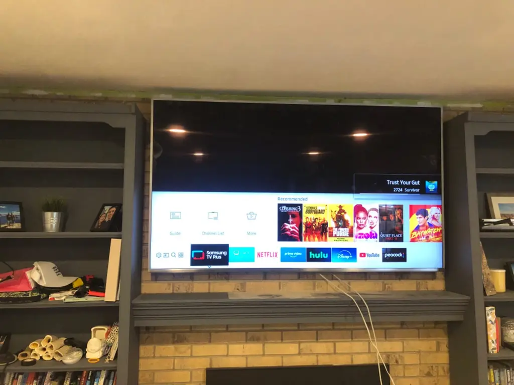 TV mounted above a brick fireplace between bookcases in Highlands Ranch
