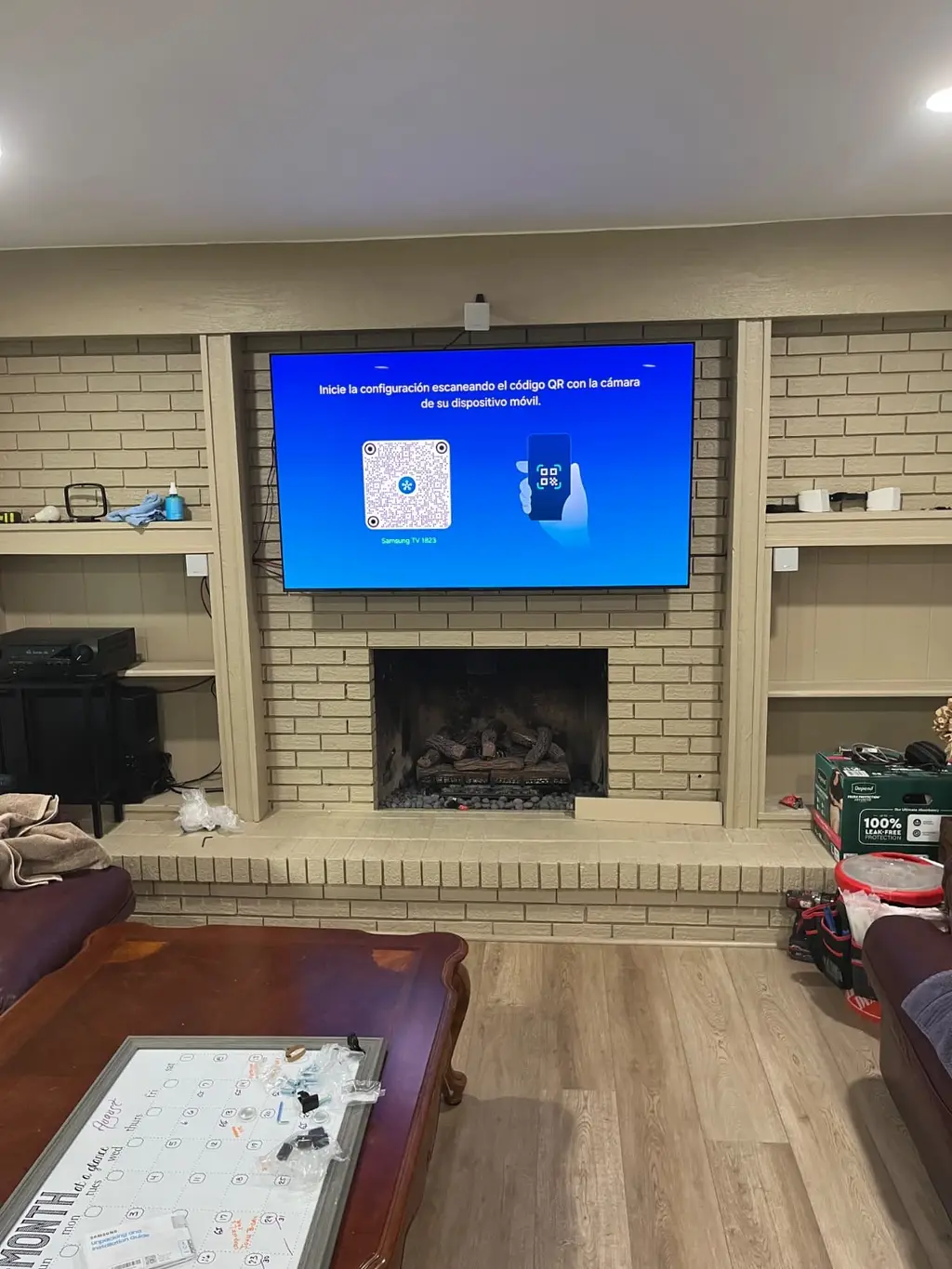 TV mounted above a painted brick fireplace between built-in shelves