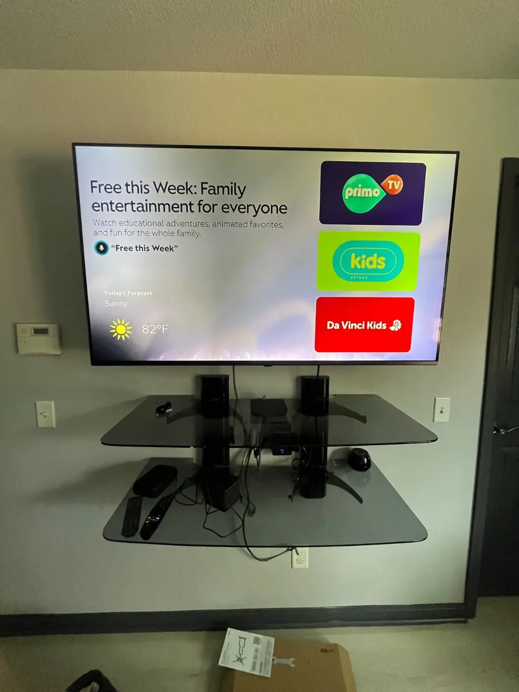 TV mounted above floating glass media shelves in Golden