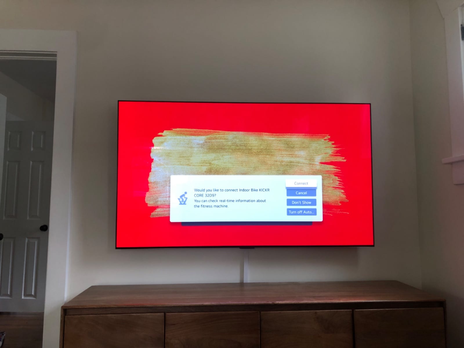 TV mounted above a wood media console
