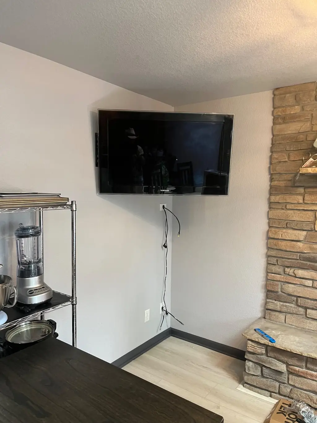 TV mounted in a corner beside a stone wall in Westminster
