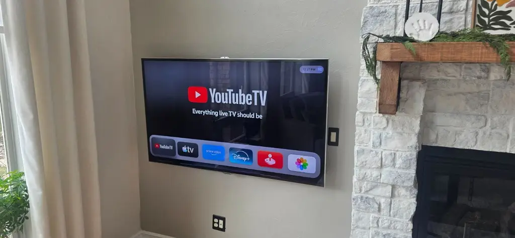 TV wall mounted beside a whitewashed stone fireplace in Centennial