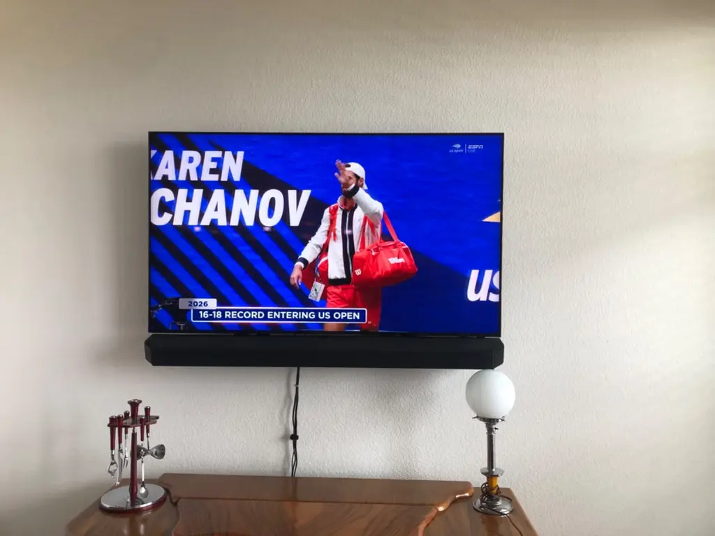 TV and soundbar mounted above a wood dresser in Littleton