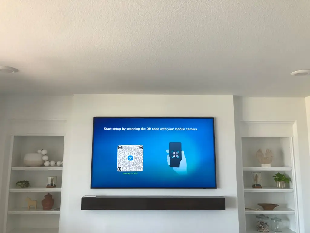 TV and soundbar mounted between white built-in shelves in a Highlands Ranch home