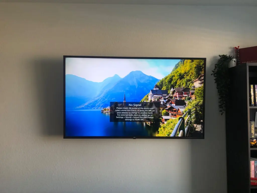 TV wall mounted beside a bookshelf in a modern living room
